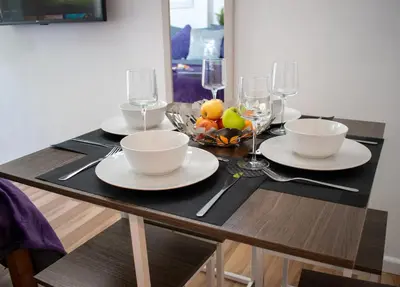 a table with two plates and a bowl of fruit at 121 Studio - Apartment with Kitchen, Terrace, Stansted Airport Shuttle in Bishops Stortford