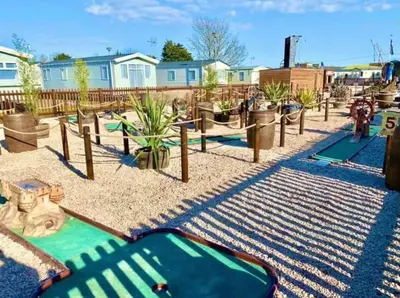 a park with a playground with a slide and plants at Lodge Sleeps 8- Parking Wifi Campsite Amenities in Jaywick Sands