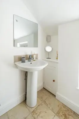 a white bathroom with a sink and a mirror at Laurel Cottage - Aldeburgh Coastal Cottages in Blyford