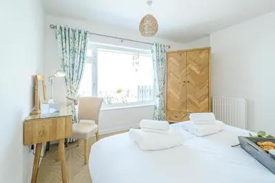 a bedroom with a bed and a desk and a window at Skippers Cottage - Aldeburgh Coastal Cottages in Aldeburgh