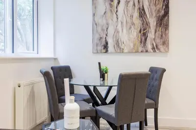 a dining room with a table and chairs and a painting at Modern 1BR By Luxiety Stays Short Lets & Serviced Accommodation Southend on sea - City Centre, Nr the beach, High St & Adventure Island in Southend-on-Sea