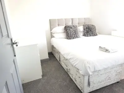 a bedroom with a large white bed with pillows at Vetrelax Colchester Three bedroom house- Sleeps up to 7 - Free Wi-Fi - Contractors - Families - Long Term Stays in Colchester