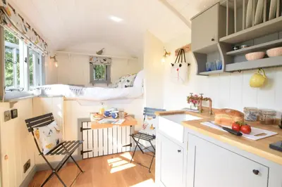 a kitchen with a table and chairs in a tiny house at Shepherds Pightle in Hollesley