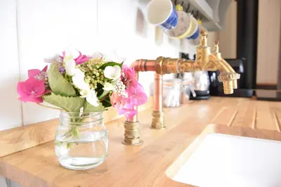 a vase of flowers sitting on a counter next to a sink at Shepherds Pightle in Hollesley