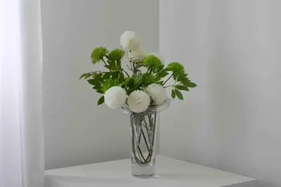 a glass vase with white flowers in it at New stylish 4 bed house moments from Clacton beach in Clacton-on-Sea