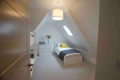a small bedroom with a bed in a attic at New stylish 4 bed house moments from Clacton beach in Clacton-on-Sea