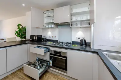 a kitchen with white cabinets and a stove top oven at My Chester Luxury Home in Colchester