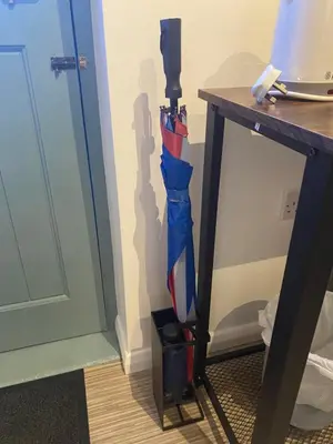 an umbrella is standing next to a table at Self-contained, Framlingham Snug, Private Parking, no cooking facilities in Framlingham