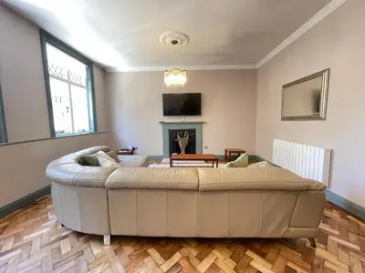 a large couch in a living room with a fireplace at Cathedral View Apartment, Flat 4 in Bury Saint Edmunds