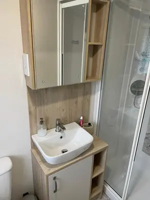 a bathroom with a sink and a shower at Mersea Villa in West Mersea