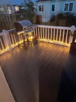 a grill on a deck with lights on it at Mersea Villa in West Mersea