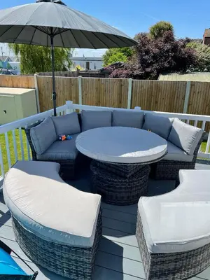 a patio with a table and chairs and an umbrella at Mersea Villa in West Mersea