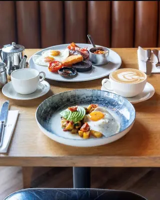 a table with two plates of breakfast food on it at The Pier Hotel in Harwich