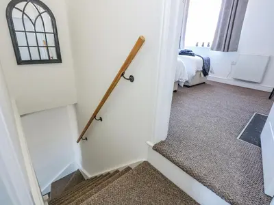 a stairway leading to a room with a bed at Lily Cottage in Downham Market