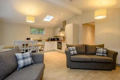 a living room with two couches and a kitchen at Woolverstone Marina and Lodge Park in Ipswich