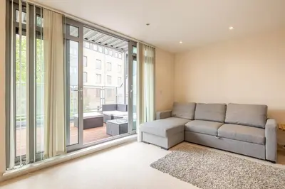 a living room with a couch and a large window at 2 BR flat next to Train Station & Gated Parking in Cambridge