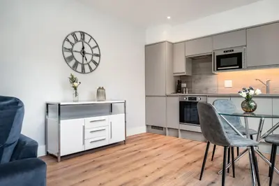 a kitchen with a table and a clock on the wall at Citystay Living - Holland Place in Cambridge