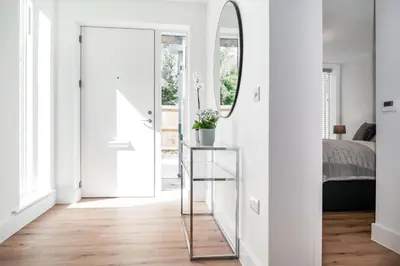 a bedroom with white walls and a mirror and a bed at Citystay Living - Holland Place in Cambridge