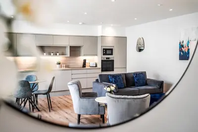a living room with a couch and a table and chairs at Citystay Living - Holland Place in Cambridge