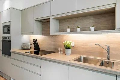 a kitchen with white cabinets and a sink at Citystay Living - Holland Place in Cambridge