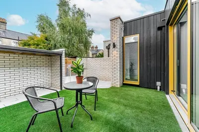 a small backyard with a table and chairs on the grass at Citystay Living - Holland Place in Cambridge