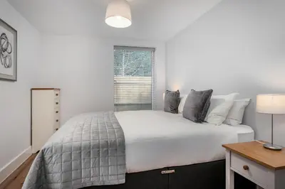 a white bedroom with a bed and a window at Citystay Living - Holland Place in Cambridge