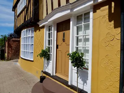 a yellow building with white windows and a door at Executive Suite with Private HotTub, Full SkyTV in 600 Year Old Manor House in Saffron Walden