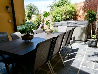 a table and chairs on a patio with plants at Executive Suite with Private HotTub, Full SkyTV in 600 Year Old Manor House in Saffron Walden