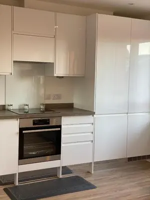 a kitchen with white cabinets and a stove top oven at Blanco Uno in Colchester