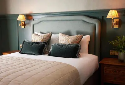 a bedroom with a large bed with pillows at Dog and Partridge by Greene King Inns in Bury Saint Edmunds