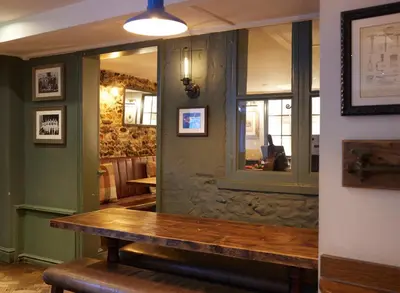 a room with a wooden table and a window at Dog and Partridge by Greene King Inns in Bury Saint Edmunds