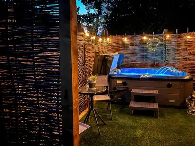 a backyard with a hot tub and a table with a chair at Peacock On The Pin in Stisted