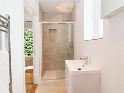 a white bathroom with a shower and a sink at Town Farm House, Orford in Orford