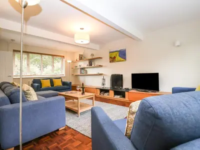 a living room with blue couches and a tv at Town Farm House, Orford in Orford