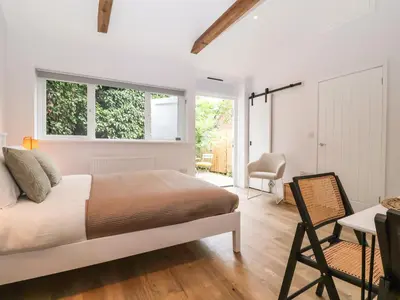 a bedroom with a bed and a table and a chair at Town Farm House, Orford in Orford