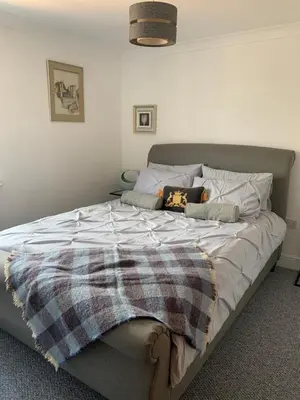 a bed with a blanket on it in a bedroom at 10 St Edmundsbury Mews in Bury Saint Edmunds