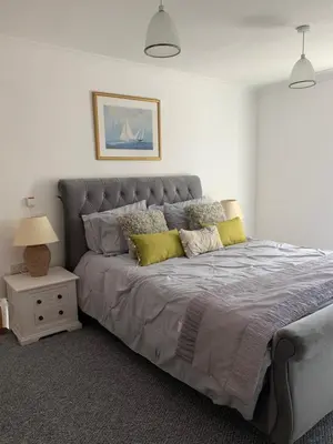 a bedroom with a large bed with yellow pillows at 10 St Edmundsbury Mews in Bury Saint Edmunds