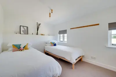 two beds in a room with white walls and windows at 4 Bed in Spexhall oc-fairs in Spexhall