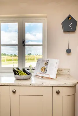 a kitchen counter with a book and a bowl of vegetables at 4 Bed in Spexhall oc-fairs in Spexhall