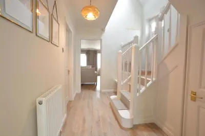 a hallway with white stairs and a stair case at The Red Brick House, Aldeburgh in Aldeburgh