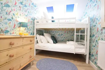 a bedroom with two bunk beds and a dresser at The Red Brick House, Aldeburgh in Aldeburgh