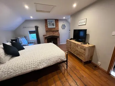 a bedroom with a bed and a tv and a fireplace at 4 Bedroom townhouse on one of the oldest streets in Wymondham