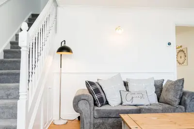 a living room with a couch and stairs at Modern and Spacious 4 Bedroom Home in Ipswich in Ipswich