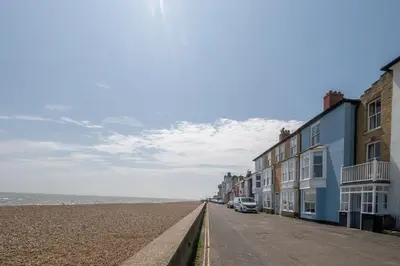 an empty street with houses on the beach at Shore View, Aldeburgh - A lovely Seafront House on famous Crag Path with uninterrupted Beach Views - Aldeburgh Coastal Cottages in Aldeburgh
