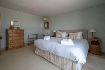 a bedroom with a large white bed with towels on it at Shore View, Aldeburgh - A lovely Seafront House on famous Crag Path with uninterrupted Beach Views - Aldeburgh Coastal Cottages in Aldeburgh