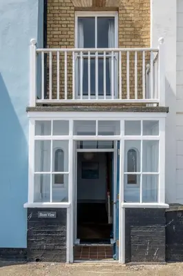 a building with a balcony on top of it at Shore View, Aldeburgh - A lovely Seafront House on famous Crag Path with uninterrupted Beach Views - Aldeburgh Coastal Cottages in Aldeburgh