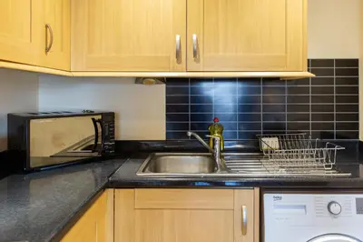 a kitchen counter with a sink and a microwave at Velvet 1-bedroom penthouse, Clockhouse, Hoddesdon in Hoddesdon