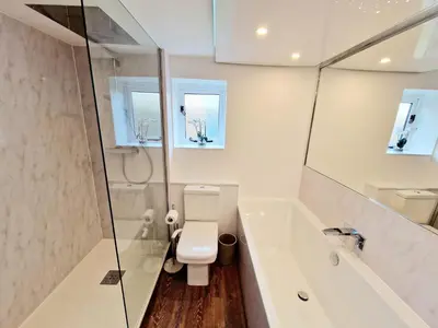 a bathroom with a toilet and a tub and a sink at Tilly's, a two bedroom holiday retreat with hot tub and views of the pond in Barningham