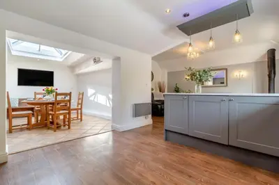 a living room with a kitchen and a dining room at Tilly's, a two bedroom holiday retreat with hot tub and views of the pond in Barningham