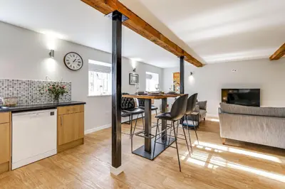 a kitchen and living room with a table and chairs at The Old Warehouse Ely in Ely
